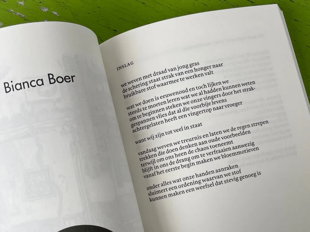 Een opgengeslagen boek met daarop het gedicht Inslag van Bianca Boer